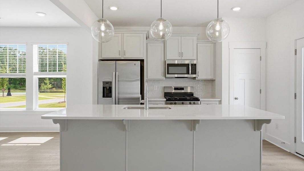 Elegant kitchen featuring a 9-foot island with pendant lighting and tasteful finishes throughout in Fountain Inn, SC