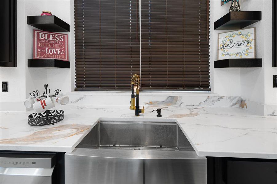Kitchen featuring open shelves, light stone countertops, and stainless steel dishwasher