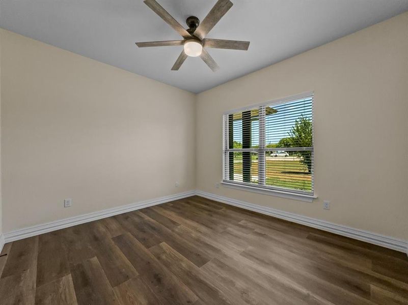 Unfurnished room with dark wood finished floors and ceiling fan Unfurnished room with dark wood finished floors and ceiling fan