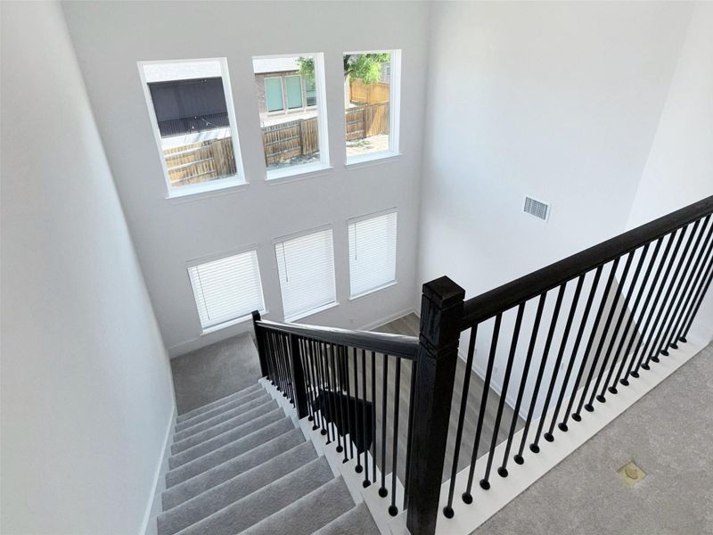 Staircase with carpet floors and a high ceiling
