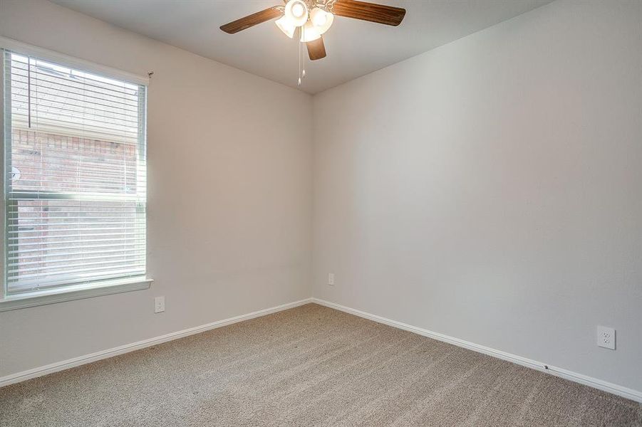 Carpeted empty room with baseboards and ceiling fan