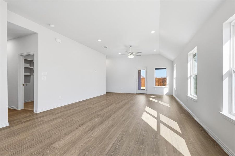 Unfurnished living room featuring light wood-style flooring, recessed lighting, vaulted ceiling, and ceiling fan