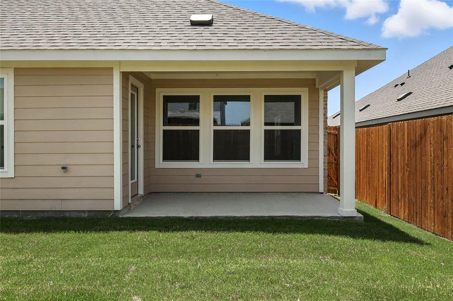 Rear view of house with roof with shingles and a patio area