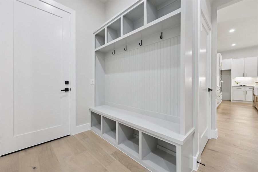 Built-in mudroom storage featuring a bench, open cubbies, and coat hooks