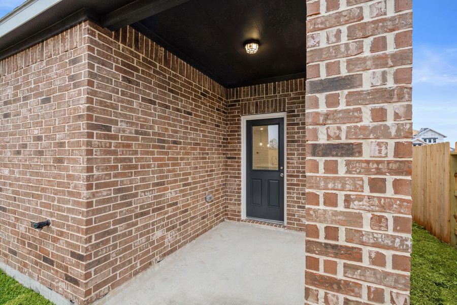 The covered patio is generously sized, providing ample space for various outdoor activities.