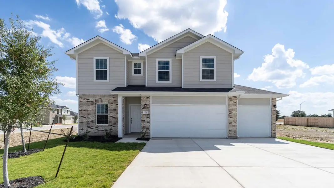 Front exterior of a new home in Grande Estates, Bertram, TX, highlighting curb appeal (Image 1).