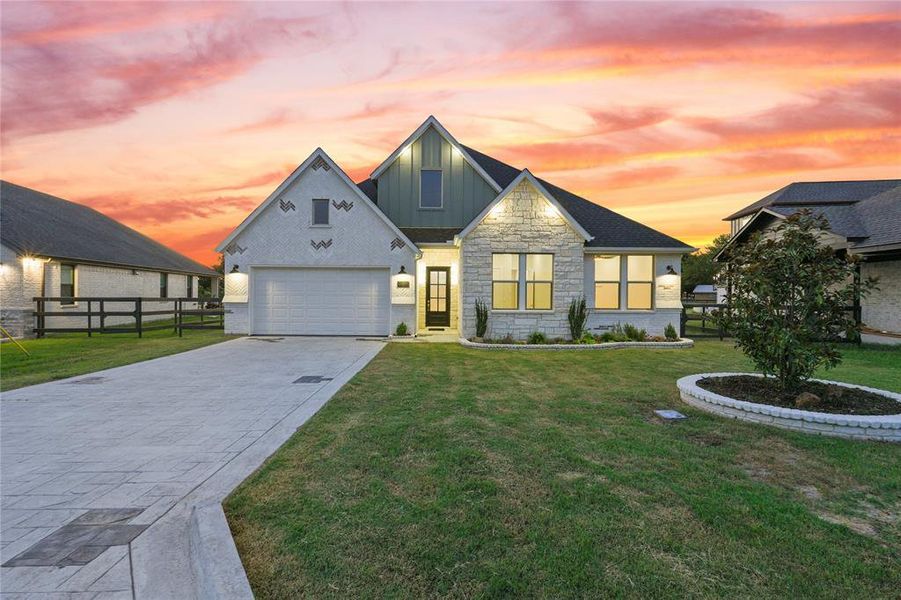 View of front of house with board and batten siding, stone siding, concrete driveway, and a garage View of front of house with board and batten siding, stone siding, concrete driveway, and a garage