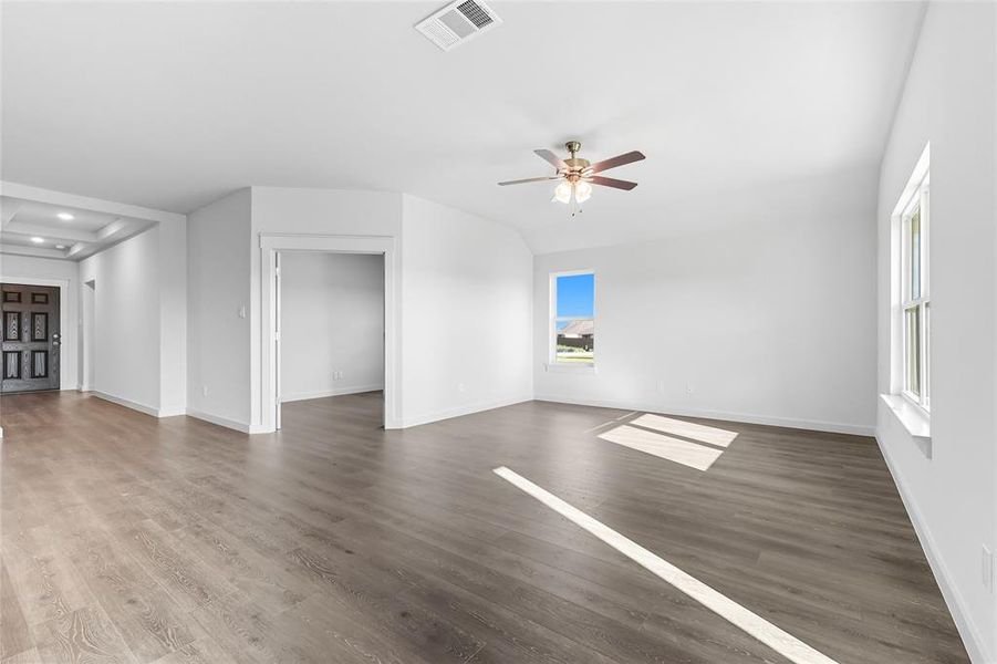 Unfurnished living room with wood finished floors, a ceiling fan, and recessed lighting Unfurnished living room with wood finished floors, a ceiling fan, and recessed lighting