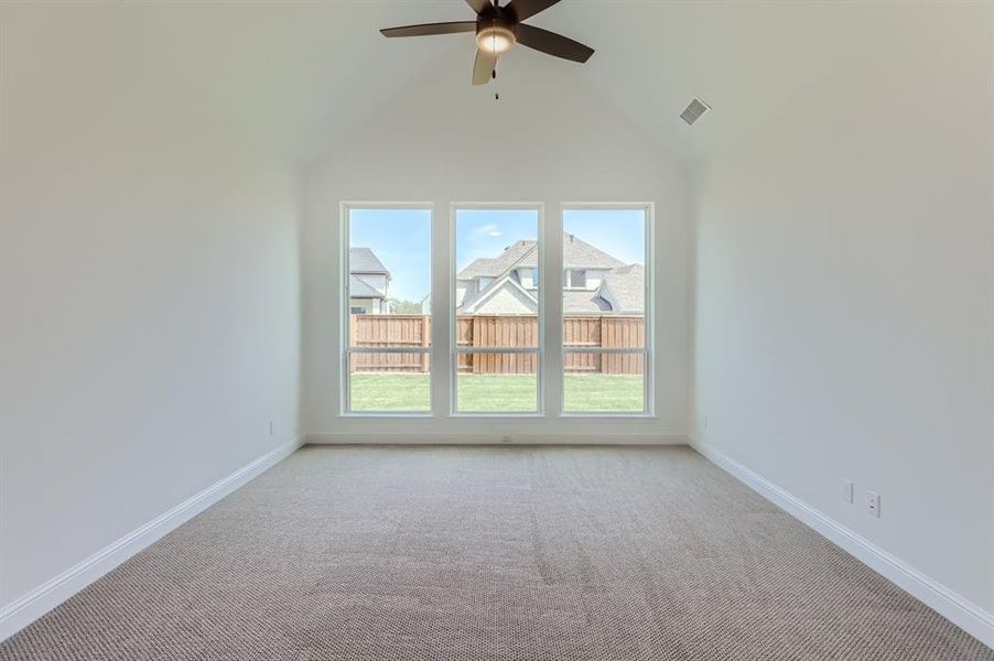 Spare room featuring high vaulted ceiling, carpet, and ceiling fan