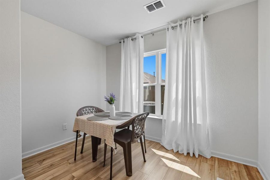 Dining room with light wood-type flooring and baseboards
