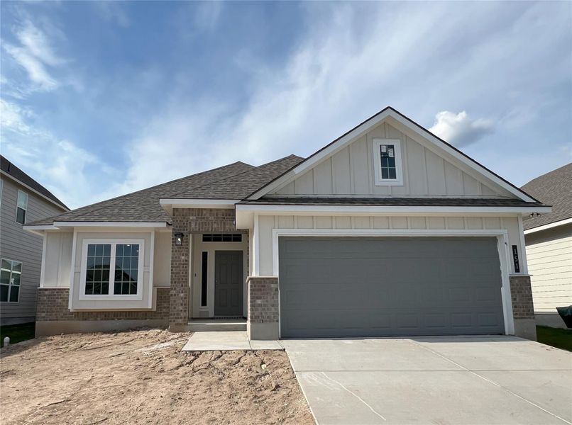 View of front of home featuring brick siding, board and batten siding, roof with shingles, concrete driveway, and a garage View of front of home featuring brick siding, board and batten siding, roof with shingles, concrete driveway, and a garage