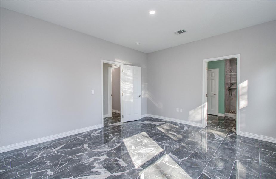This room features modern gray walls with glossy marble flooring, ample natural light, and two doorways leading to additional spaces.