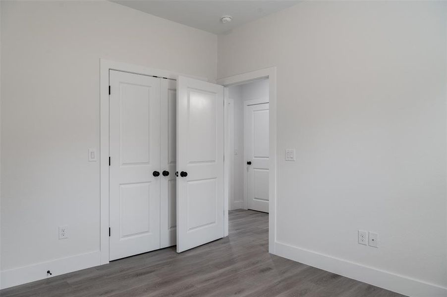 Unfurnished bedroom with hardwood / wood-style flooring and a closet