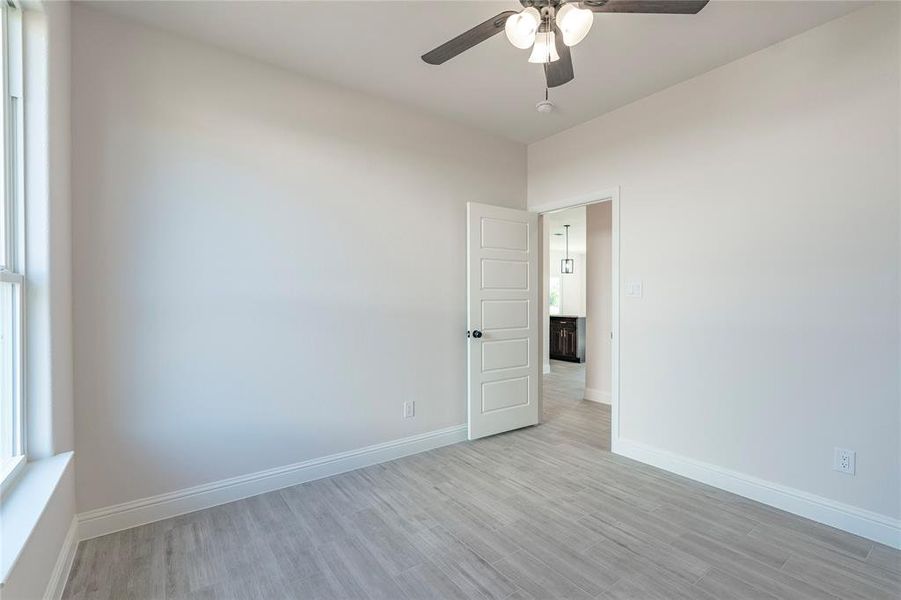 Empty room featuring ceiling fan and light hardwood / wood-style flooring