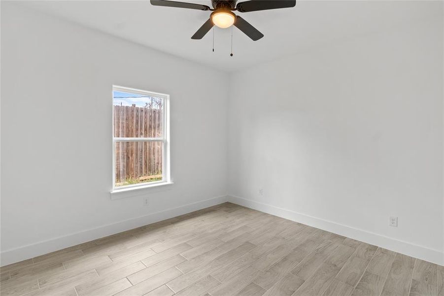 Unfurnished room with ceiling fan, plenty of natural light, and light hardwood / wood-style floors