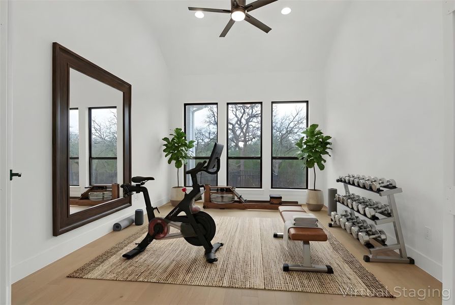Virtually-Staged Flex Room featuring light hardwood flooring, high vaulted ceiling, ceiling fan, recessed lighting, and scenic, greenbelt view