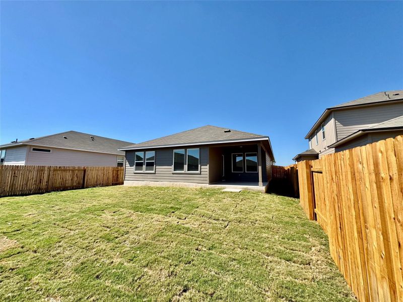 Rear view of house featuring a patio area, a fenced backyard, and roof with shingles Rear view of house featuring a patio area, a fenced backyard, and roof with shingles