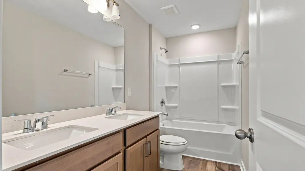 Secondary bathroom with elevated designs of dual vanities paired with spacious bath and shower. Secondary bathroom with elevated designs of dual vanities paired with spacious bath and shower.