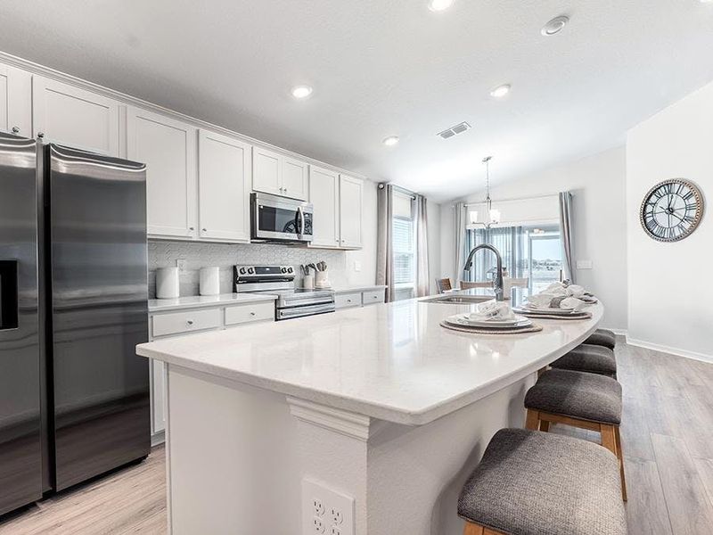 Enjoy a bright, open kitchen with a counter-height island - Raychel by Highland Homes
