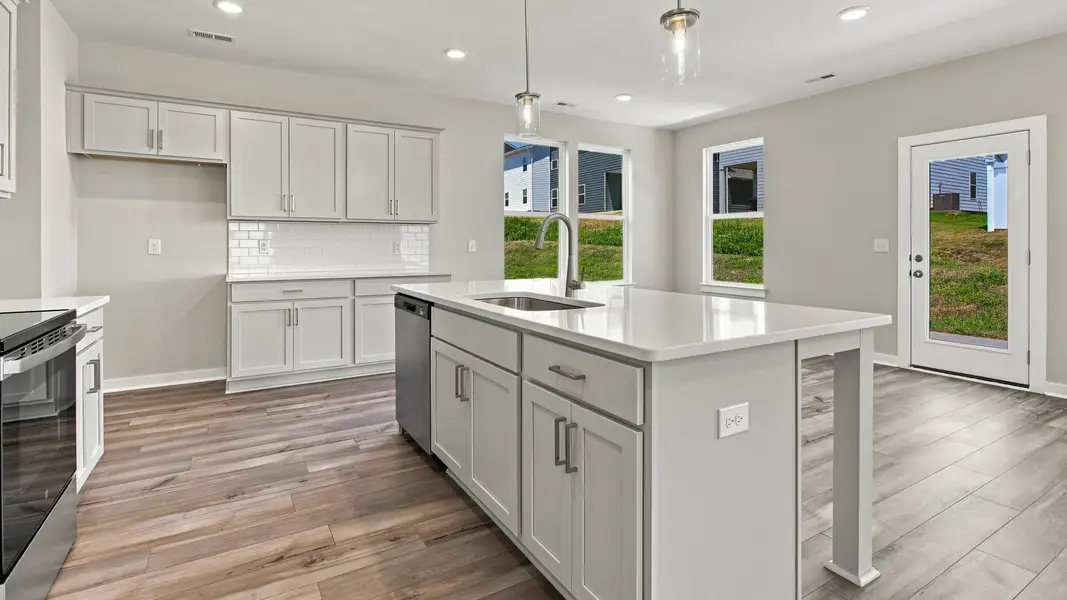 Closer view of elevated kitchen island with cabinet space alongside sink and dishwasher Closer view of elevated kitchen island with cabinet space alongside sink and dishwasher