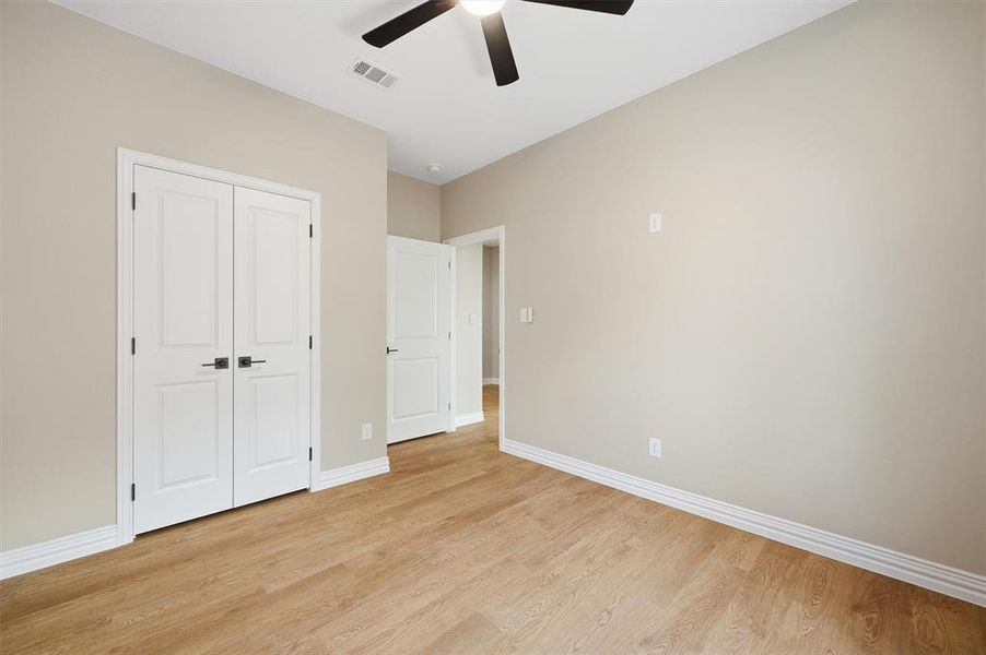 Unfurnished bedroom with light wood finished floors, a ceiling fan, and a closet Unfurnished bedroom with light wood finished floors, a ceiling fan, and a closet