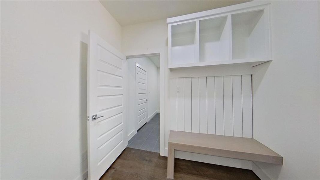 Mudroom featuring dark wood-style floors and baseboards
