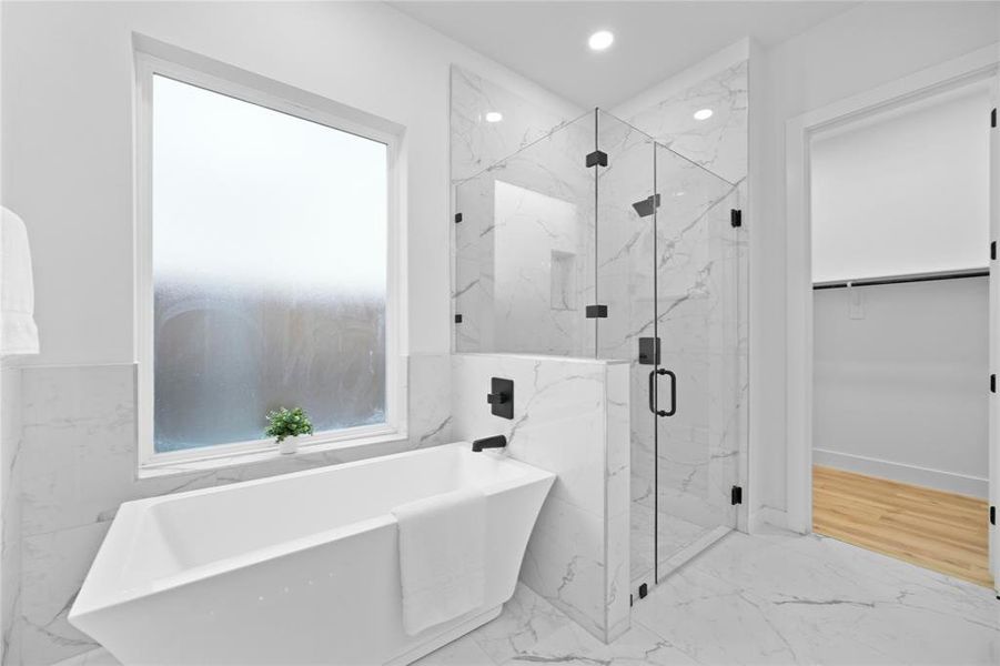 Full bathroom featuring a freestanding tub, marble finish flooring, a marble finish shower, and recessed lighting Full bathroom featuring a freestanding tub, marble finish flooring, a marble finish shower, and recessed lighting