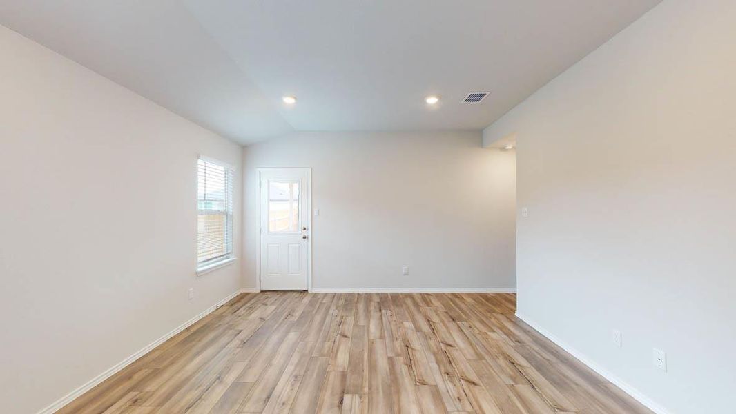 Open concept living space featuring wood-finish flooring, recessed lighting, and a white paneled door with glass inserts