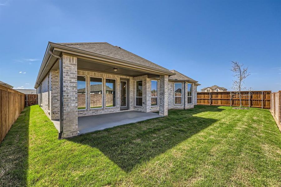 Rear view of house featuring a lawn and a patio