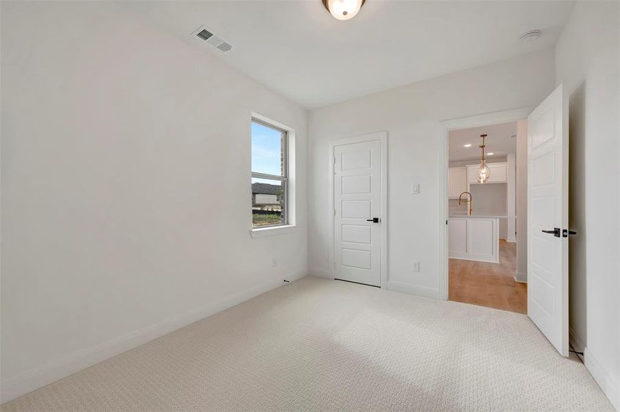 Unfurnished bedroom featuring light colored carpet and baseboards