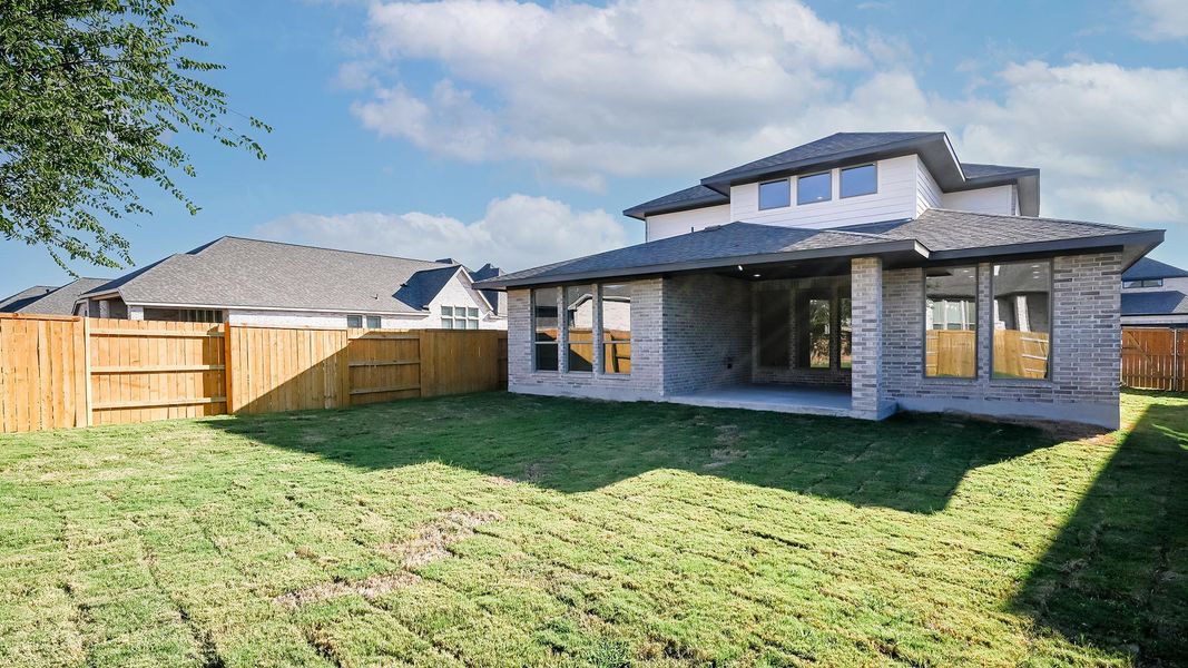 Rear view of house with brick siding, a fenced backyard, and a patio area Rear view of house with brick siding, a fenced backyard, and a patio area