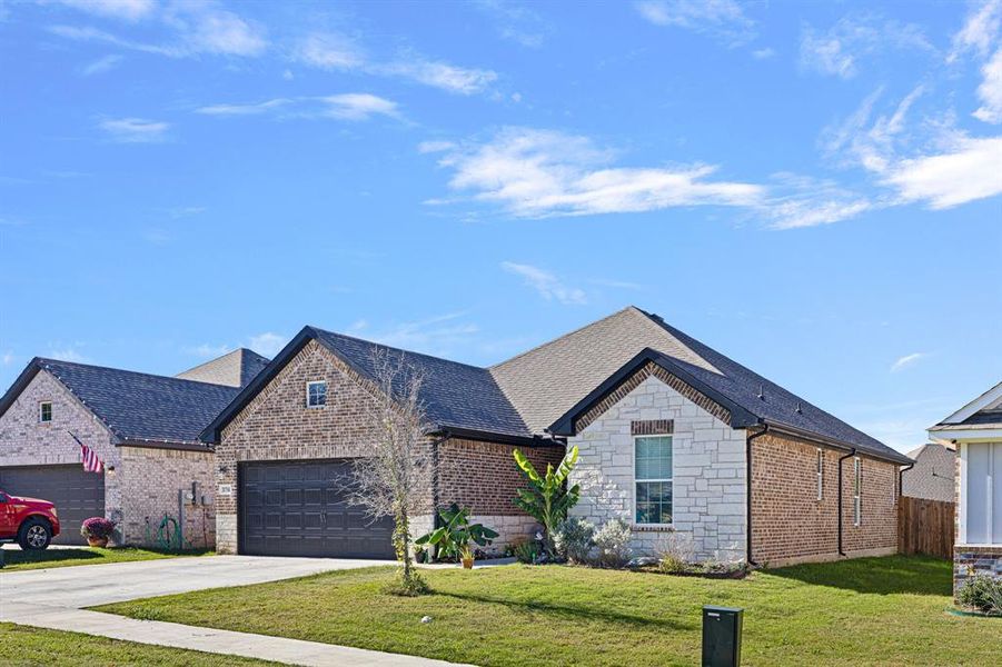 View of front facade featuring a front lawn and a garage