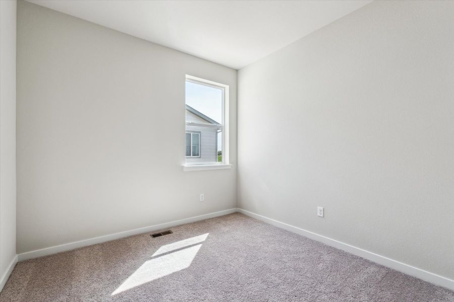 A room with a window and carpet.