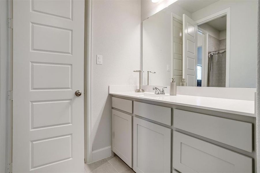 Bathroom featuring vanity, baseboards, tile patterned flooring, and a shower with shower curtain Bathroom featuring vanity, baseboards, tile patterned flooring, and a shower with shower curtain