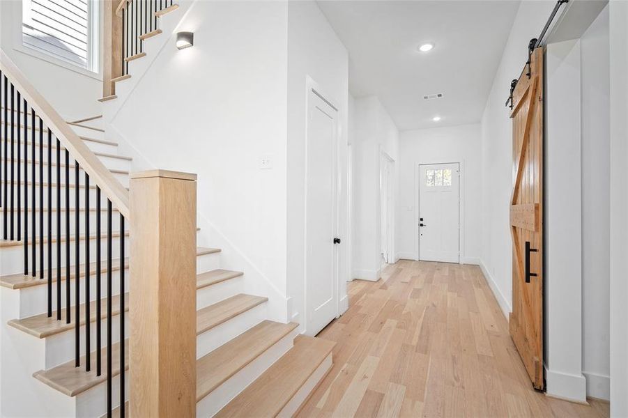 Stepping back downstairs looking towards the entrance, you'll find another hallway closet on the left and mudroom on the right hand side. The barn door features a soft closing mechanism.