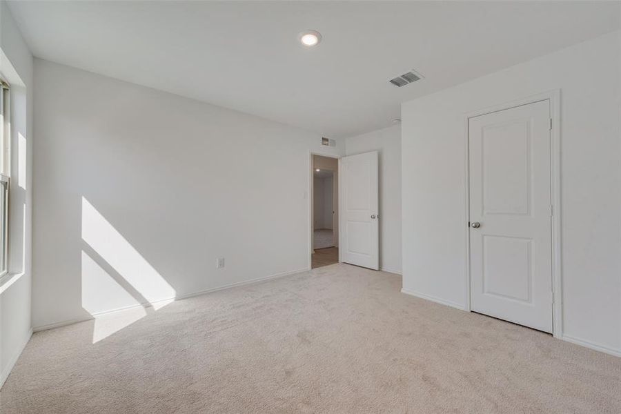 Unfurnished bedroom featuring light colored carpet