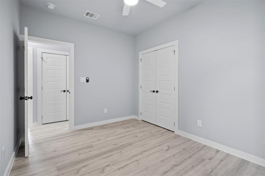 Unfurnished bedroom featuring light wood-type flooring, a closet, and a ceiling fan Unfurnished bedroom featuring light wood-type flooring, a closet, and a ceiling fan