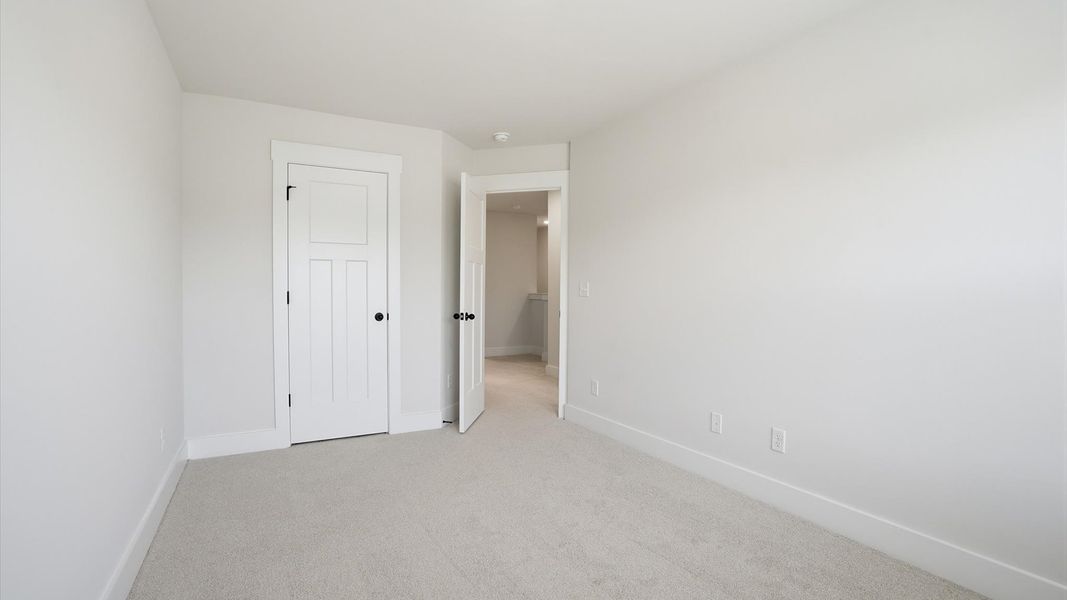 Vibrant and inviting secondary bedroom featuring a walk-in closet and refined finishes at Barton Hollow Vibrant and inviting secondary bedroom featuring a walk-in closet and refined finishes at Barton Hollow