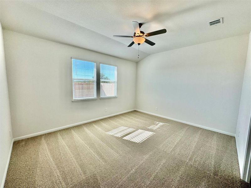 Spare room with light carpet, lofted ceiling, and ceiling fan Spare room with light carpet, lofted ceiling, and ceiling fan