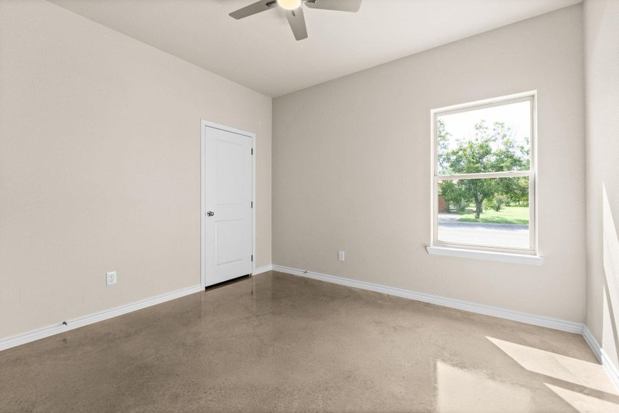 Spare room with concrete floors and ceiling fan