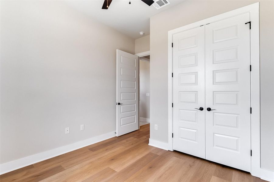 Unfurnished bedroom with light wood finished floors, a ceiling fan, and a closet