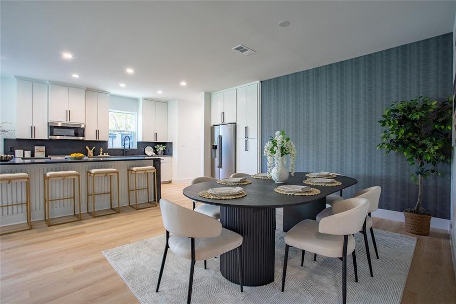 Dining area with sink and light hardwood / wood-style flooring