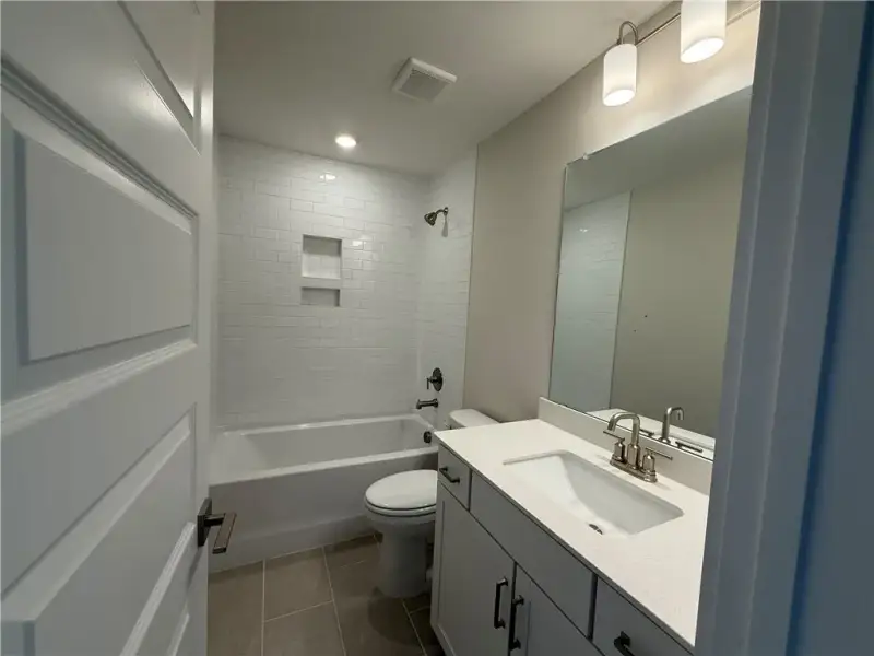 Tiled tub surround meets modern vanity and stone c