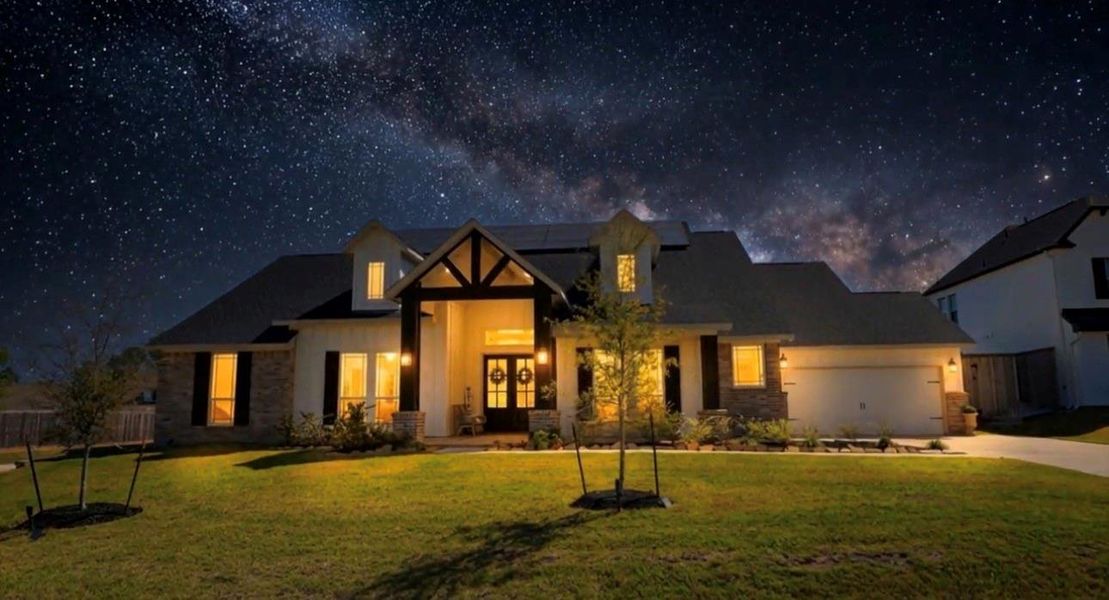 This photo showcases the stunning starry sky. The home features a welcoming front porch, manicured lawn, and a spacious garage, offering a serene and inviting atmosphere.