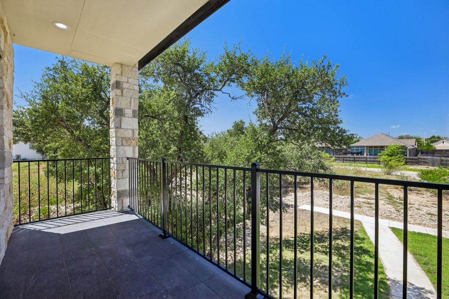A covered stone balcony overlooks the surrounding neighborhood landscape.