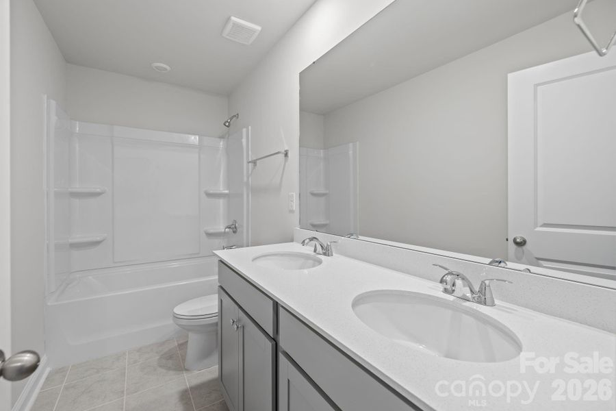 Hall bath with quartz countertops and tile flooring Hall bath with quartz countertops and tile flooring