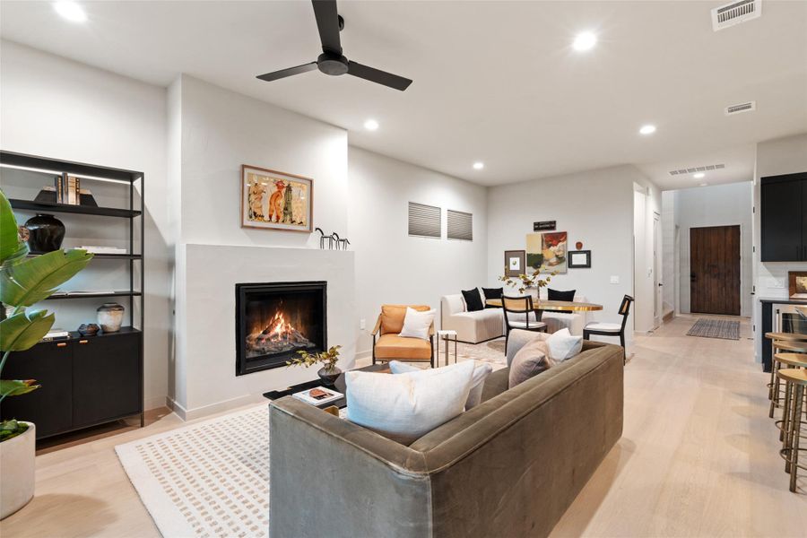 A well-lit, open-concept living area with a fireplace and modern design touches. A well-lit, open-concept living area with a fireplace and modern design touches.