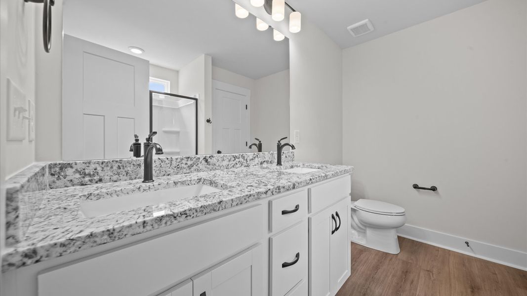 Spacious and modern primary bathroom with walk-in shower and first-class double vanity setup