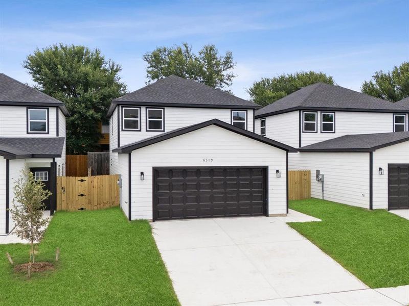 View of front of property with a front lawn and a garage