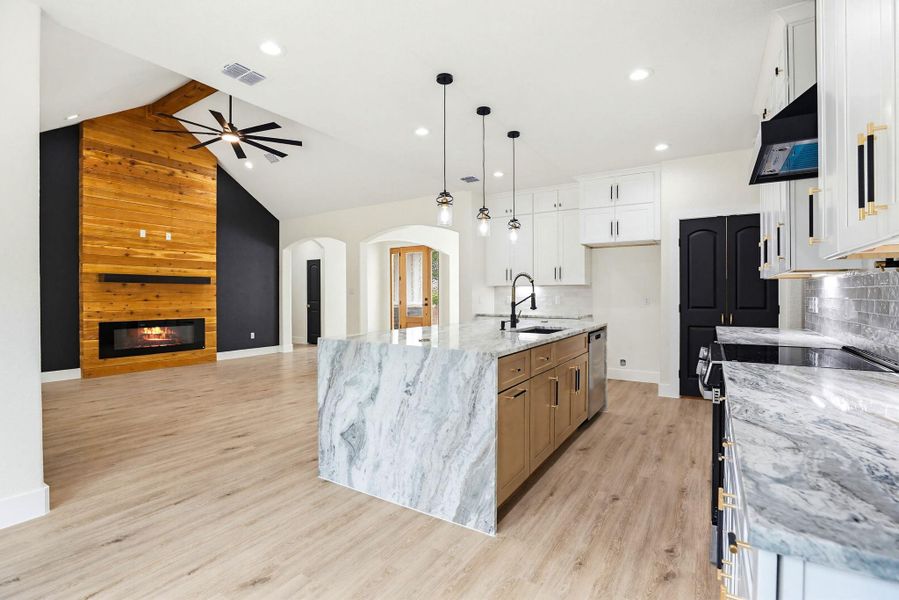 An open concept design seamlessly connects the kitchen and living area, highlighted by a striking waterfall island.